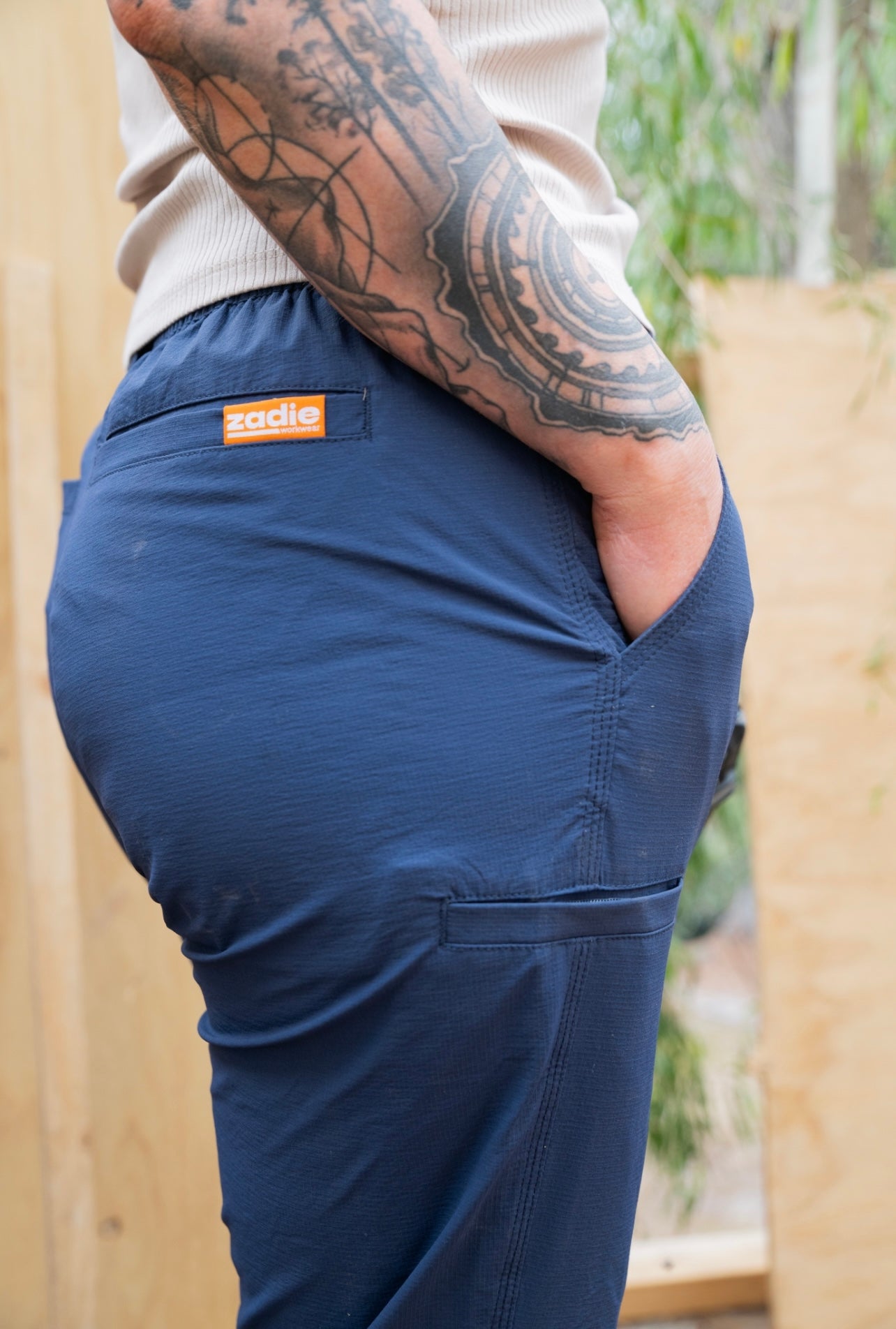 Female model in Zadie Workwear's navy work pants, highlighting the DUO-COMFORT waistband.